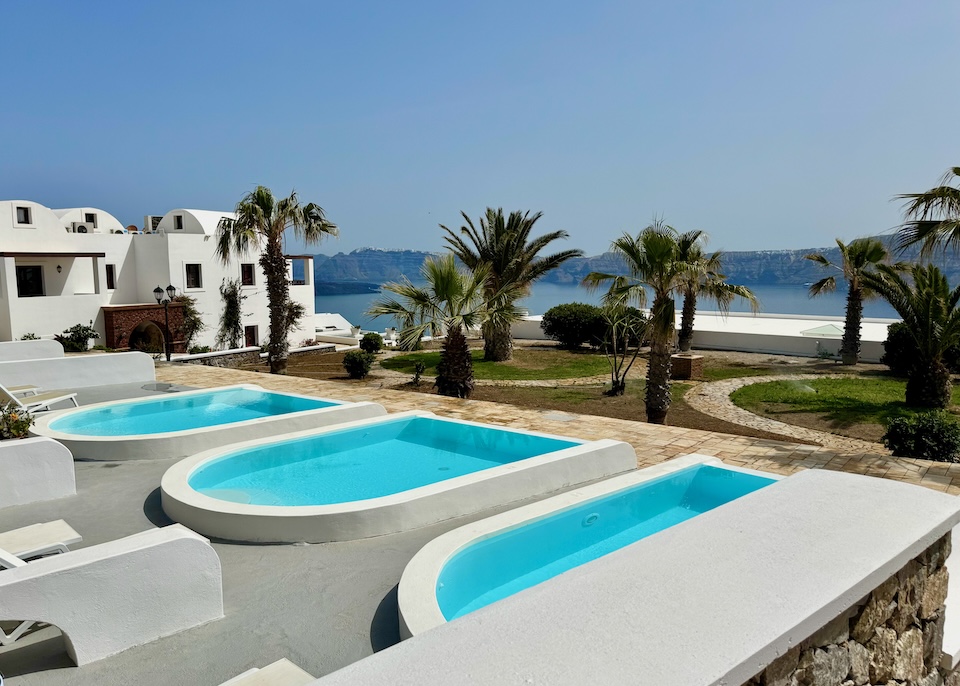 Three private plunge pools lined up in front of their respective suites at Maison des Lys hotel in Akrotiri, Santorini.