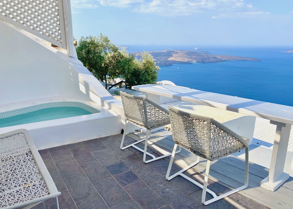 A private pool next to a privacy wall on a covered terrace with caldera views over the volcanoes at Mill Houses in Firostefani, Santorini.