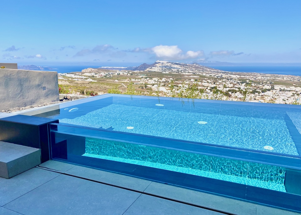 A glass-sided infinity pool with north-facing, panoramic views toward the caldera and Aegean side of the island at North hotel in Pyrgos, Santorini.