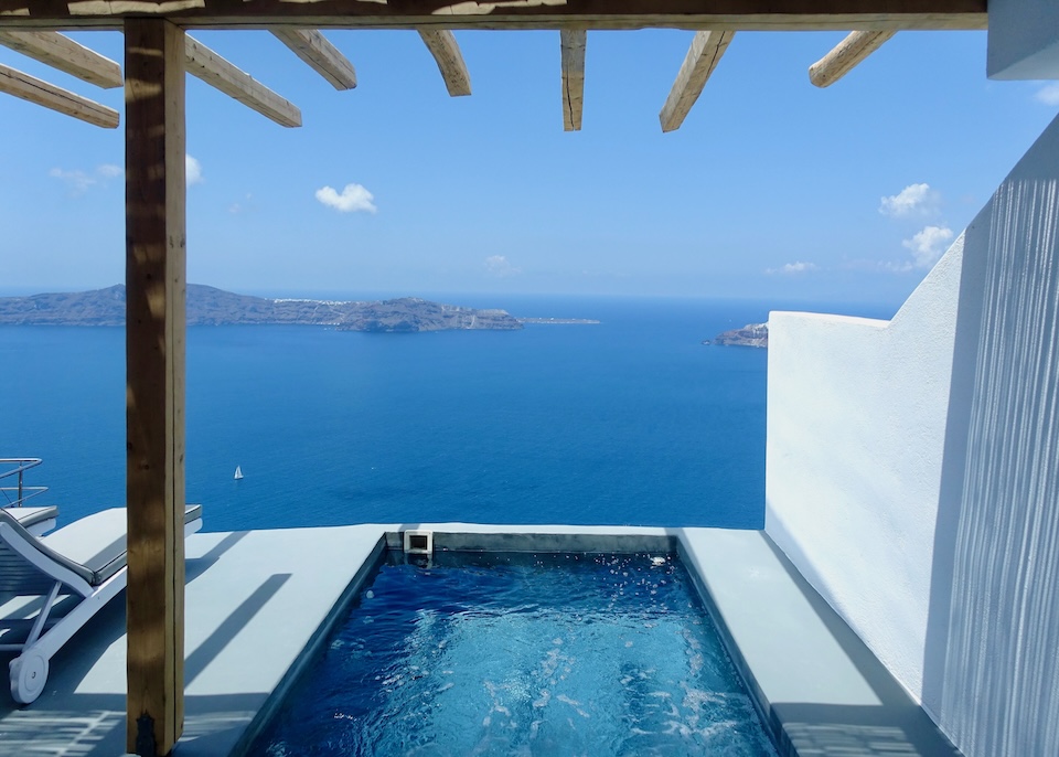 An outdoor infinity plunge pool under partially covered by a pergola at Remezzo Suites in Imerovigli, Santorini.