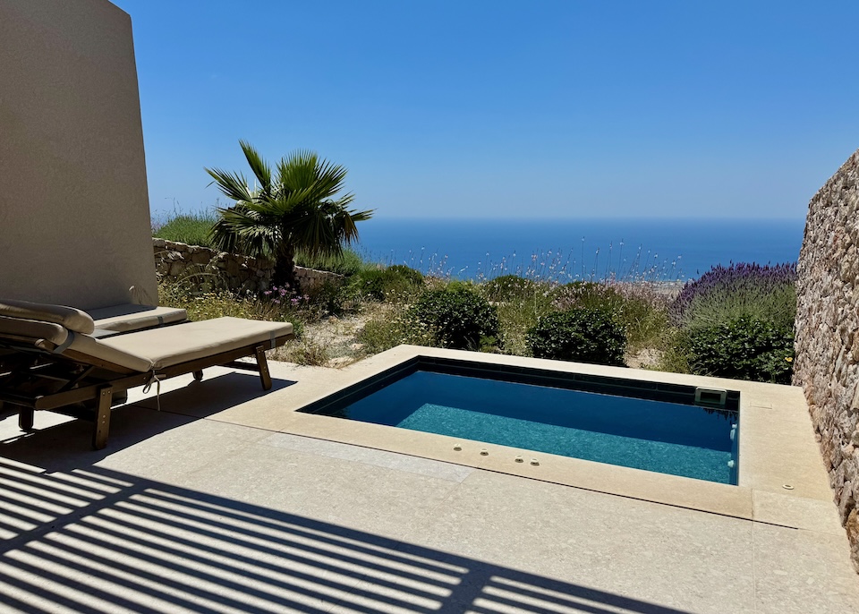 A private jacuzzi on a cozy patio behind a green garden above the caldera at Santorini Sky in Pyrgos, Santorini.