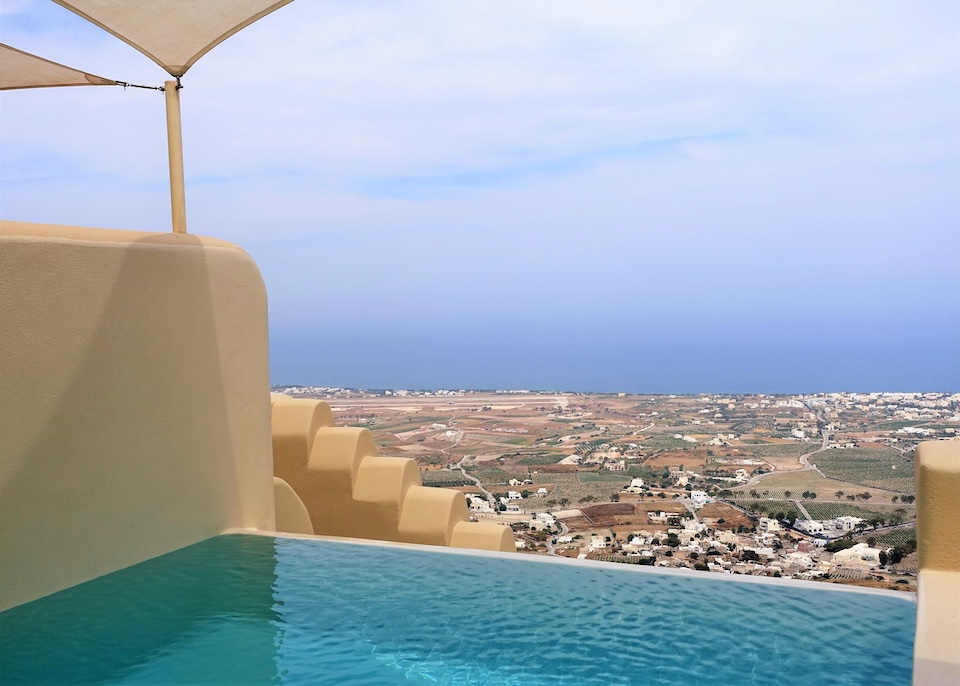 An infinity edge pool with panoramic views over the island at Skyfall Suites in Pyrgos, Santorini.