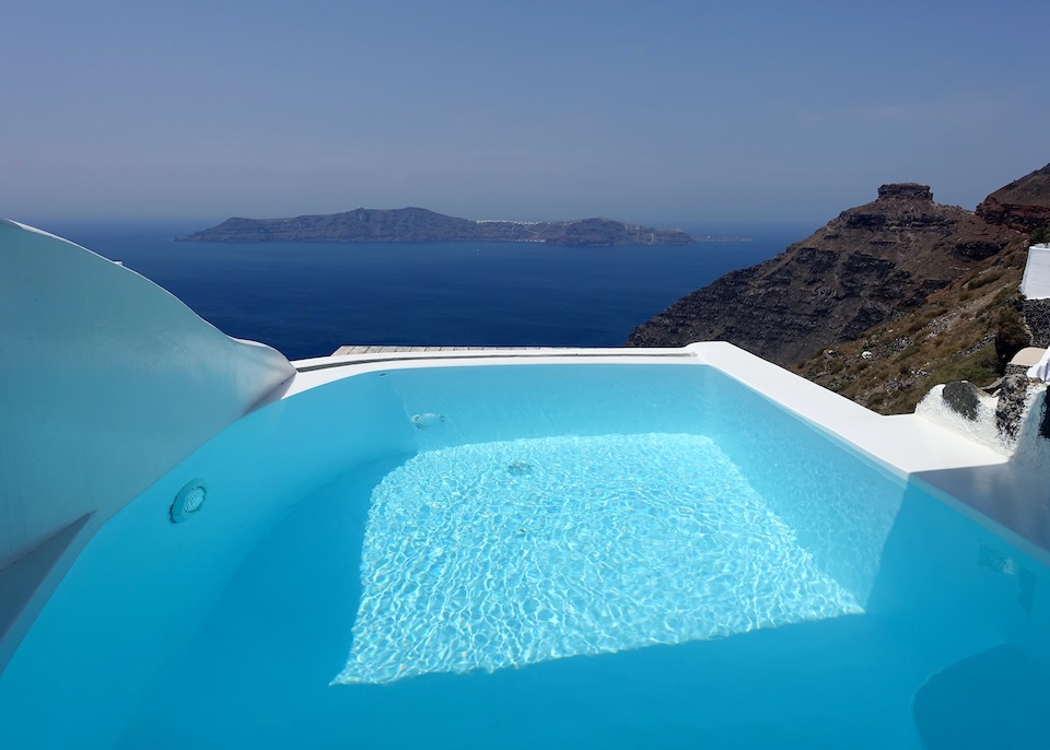 A private pool next to a privacy wall on a private terrace facing Thirassia and Skaros Rock at Sun Rocks hotel in Firostefani, Santorini.