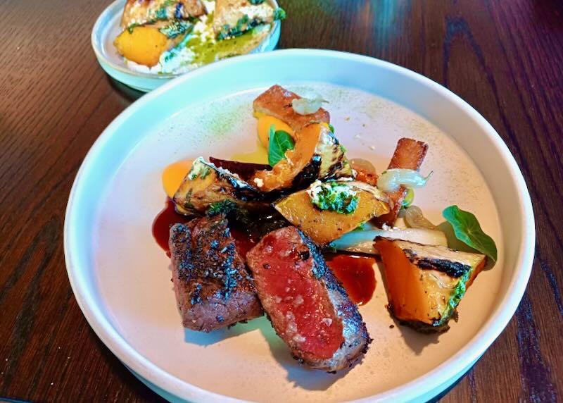 A plate with steak and squash.