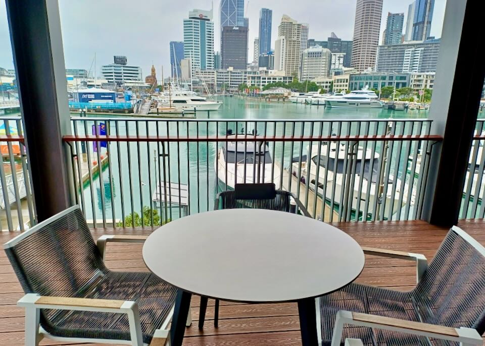 Two chairs sit on a deck overlooking a marina.