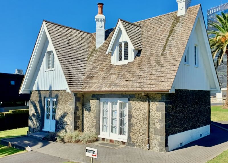 A small house with a triangle roof.