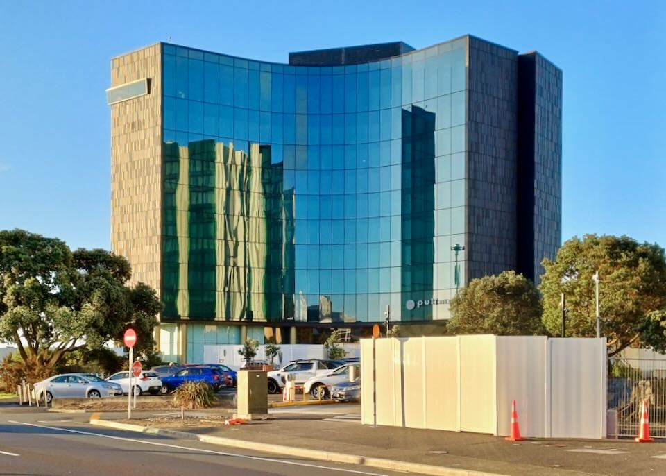 A hotel with a wall of windows reflects the sky.