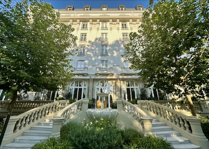 White marble split stairway, leading down to an outdoor courtyard