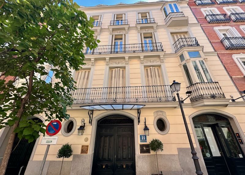 View looking up at the exterior of an elegant white hotel in Spain