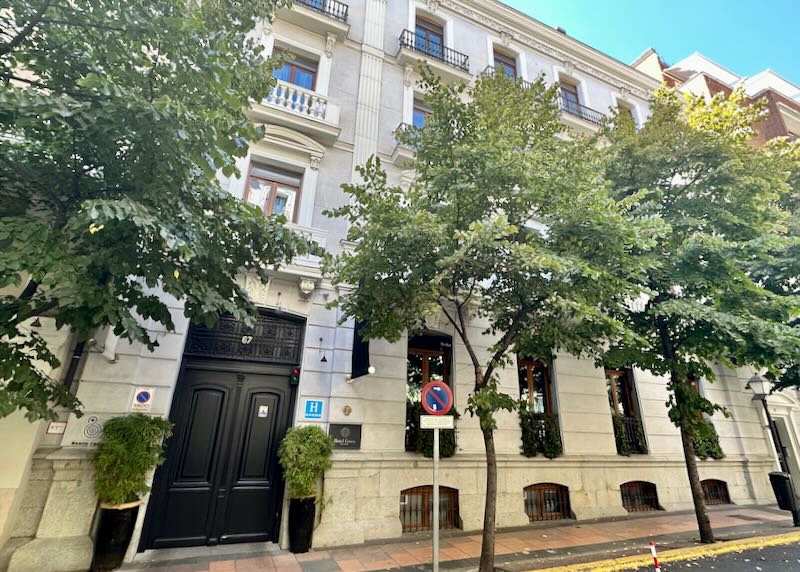 Exterior view of a small hotel on s tree-lined street in Madrid