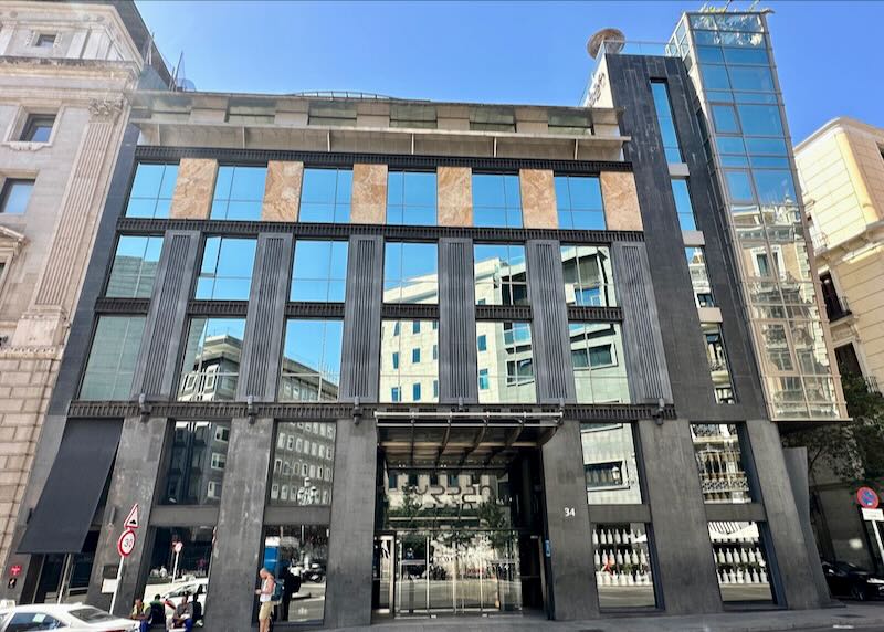 Modern hotel with large mirrored windows reflecting the sky above