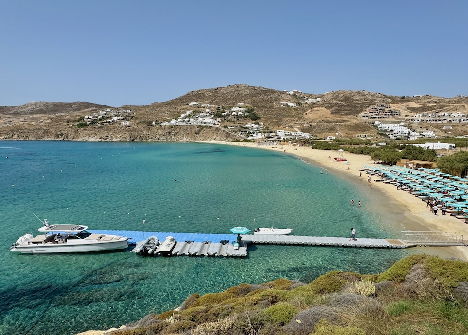 A temporary, floating pier with a boat docked in front of Kalo Livadi Beach in Mykonos.