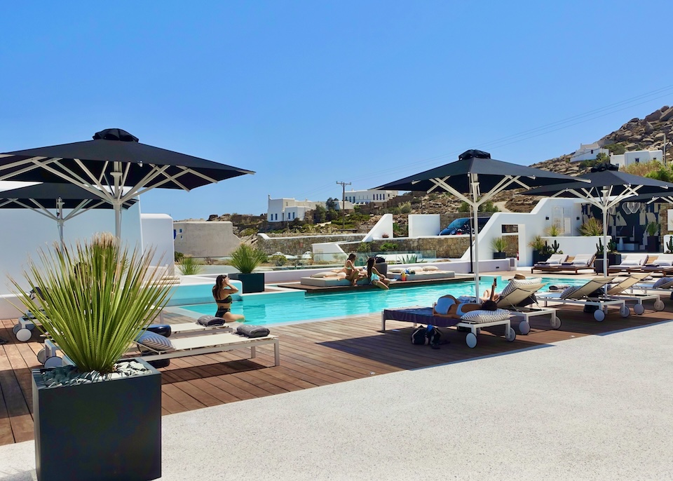 People lounging in the pool and sunbeds at Amyth of Mykonos near Super Paradise Beach in Mykonos.