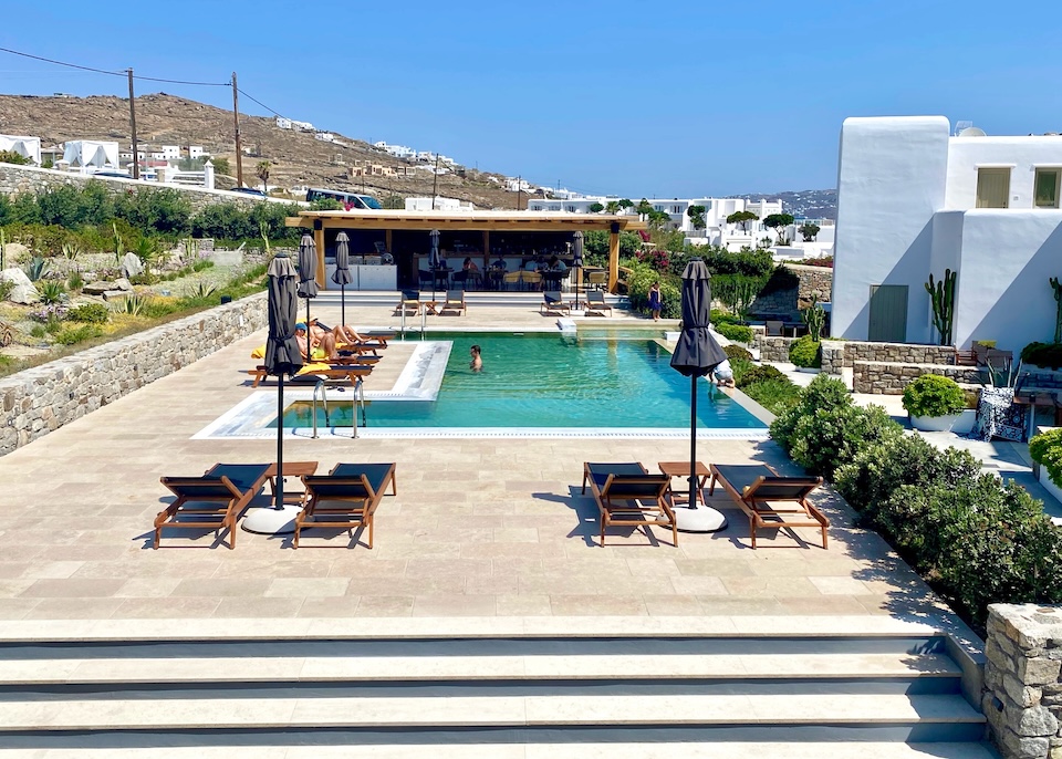 A geometric pool on a stone terrace with sunbeds and a pool bar at Mykonos Cactus in Ornos, Mykonos.