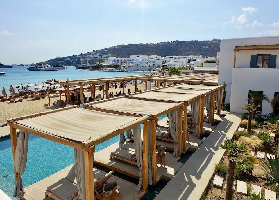 View from above a row of poolside cabanas facing the beach and sea at Branco hotel in Platis Gialos, Mykonos