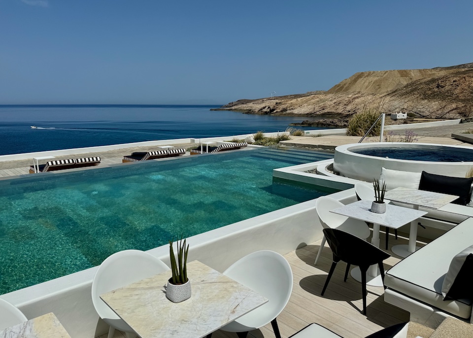 A rectangular infinity pool next to a circular jacuzzi on a hill above the sea at Semeli Coast hotel on Merchia Beach, Mykonos.