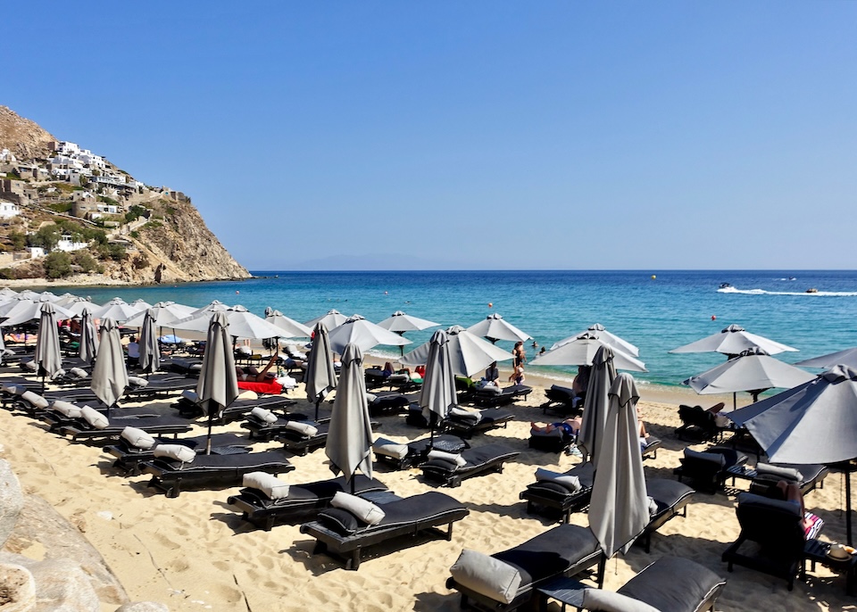 Four rows of sunbed and umbrella sets on Elia Beach in Mykonos.