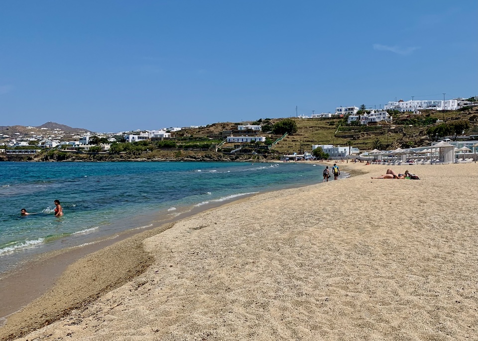 A wide, sandy beach with just a few people at Megali Ammos Beach near Mykonos Town.