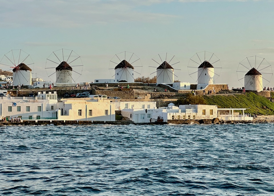 View from across the sea of the six iconic windmills in Little Venice, Mykonos Town.