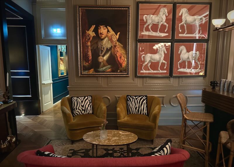 Lounge with vintage furnishings, zebra-printed cushions, and bold artwork