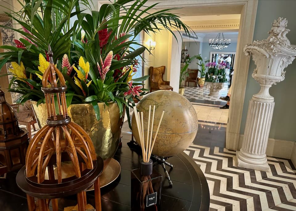 View of a hotel lobby, seen through greenery on an occasional table