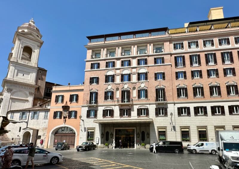 Exterior of a pink hotel in Rome, next to a bell tower