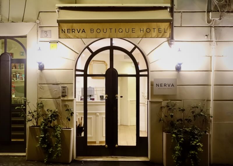 Arched doorway of a boutique hotel building with signage in front