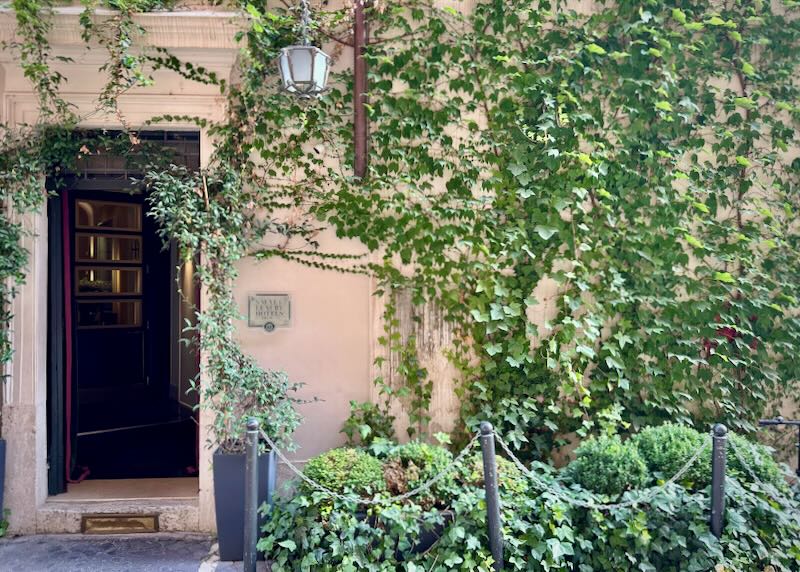 Charming and rustic pink stone doorway overhung with vines