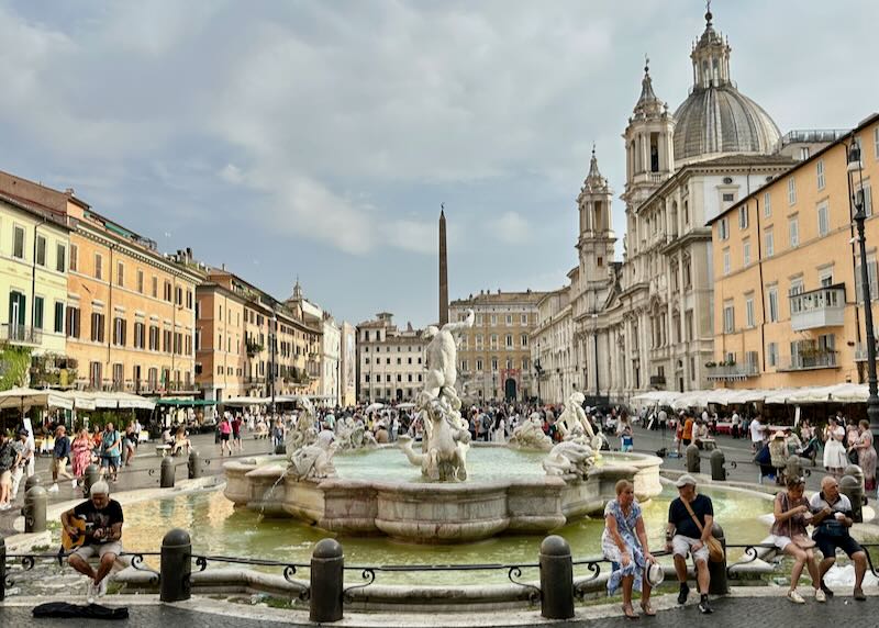 Tourists sit around a fountain in the middle of Piazza Navona in Rome.