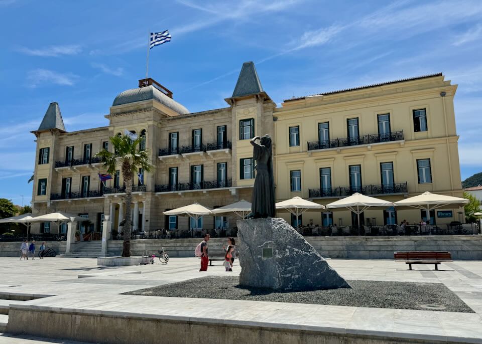 Grand hotel flying a Greek flag on a pedestrian plaza