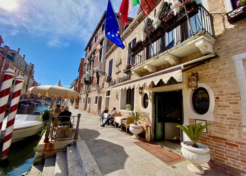 Side view of a canalside hotel in Venice's Cannareggio district, with flags flying in front 