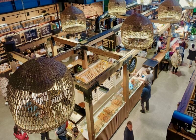 A second floor view looking down on bakery stalls showcasing cinnamon rolls and bread.