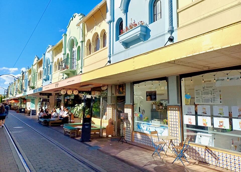 A row of colorful shops line a pedestrian street.