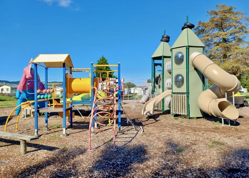 Colorful playground equipment sits in a park.