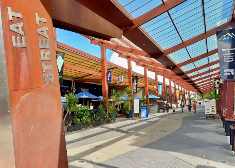 A rusted metal overhang has "Eat Streat" written on it.