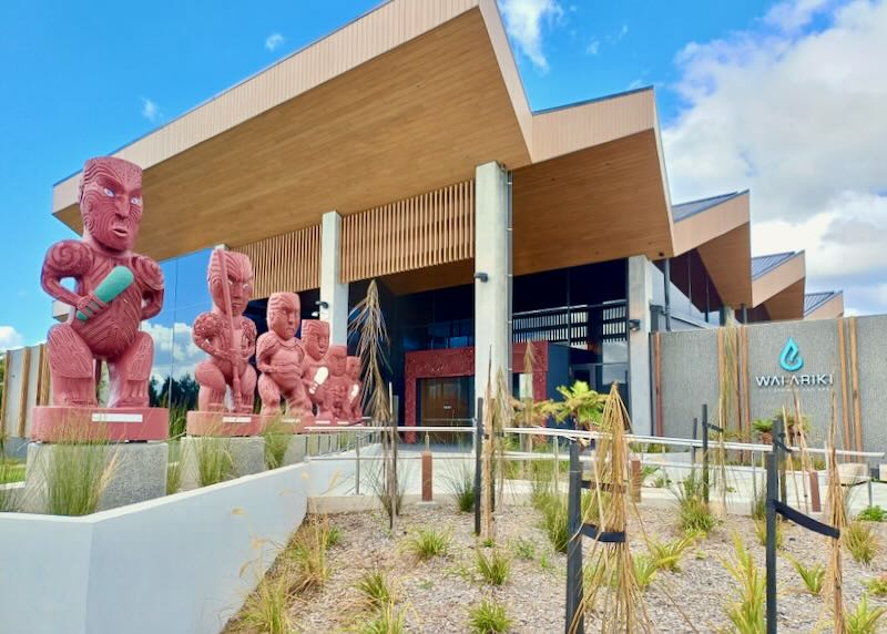 Large tribal sculptures line the entrance to a wellness center.