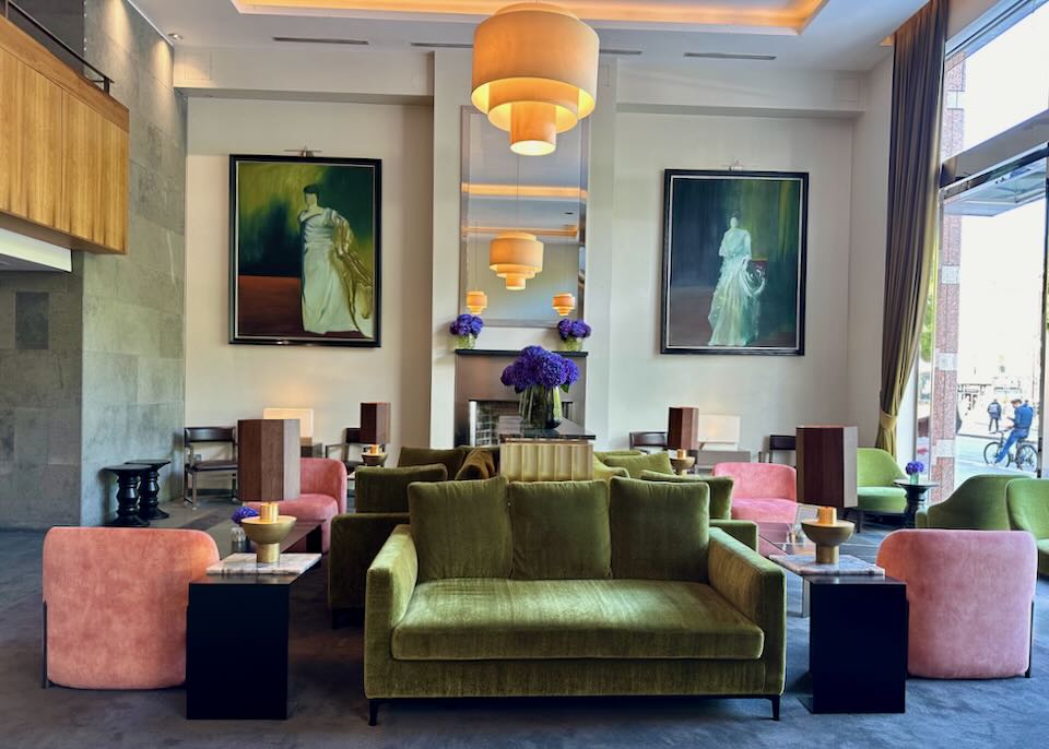 Hotel lobby with plush pastel velvet furnishing and fine art on the wall