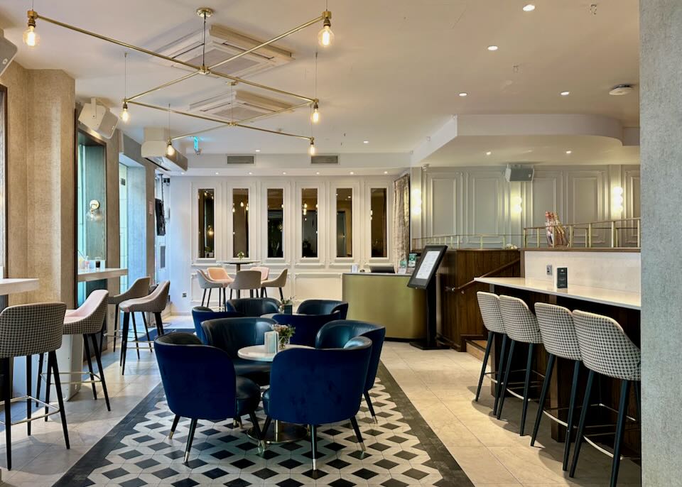 Seating area of a hotel lobby, with leather chairs and marble-topped tables