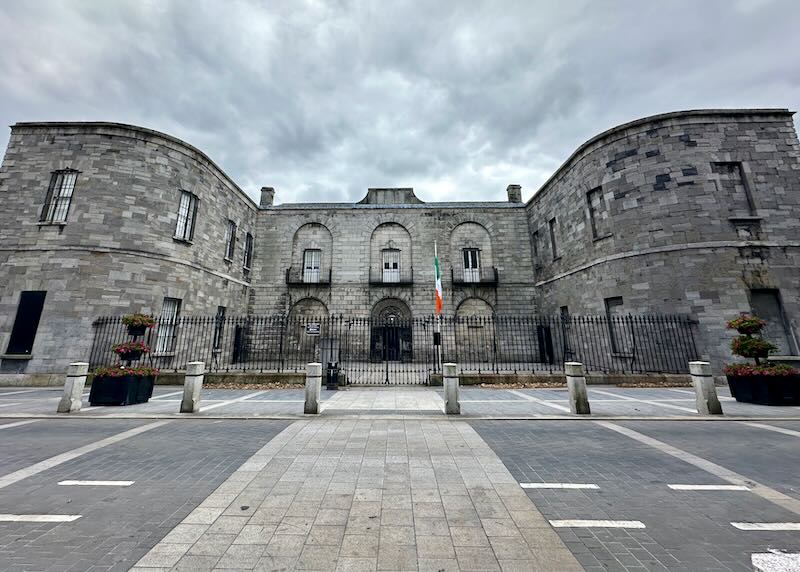 Exterior of a grey stone prison building on a cloudy day