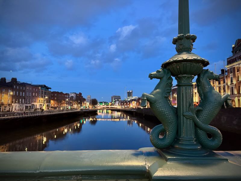 The River Liffey as seen from the Grattan Bridge in Dublin at night, with lights shining on the water.