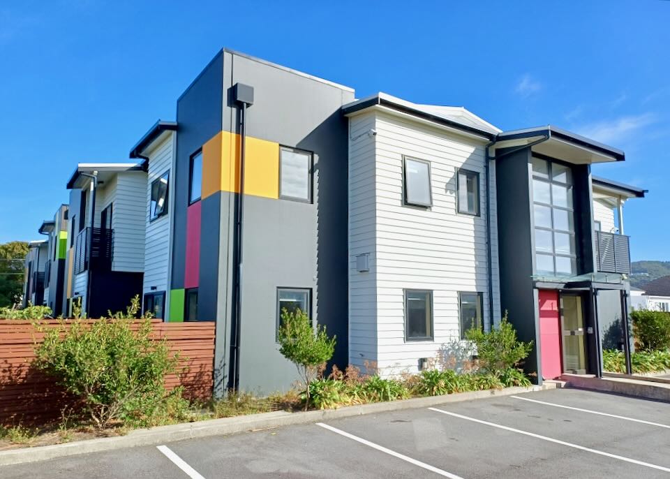 A grey building with bright yellow, red, and green color blocks.