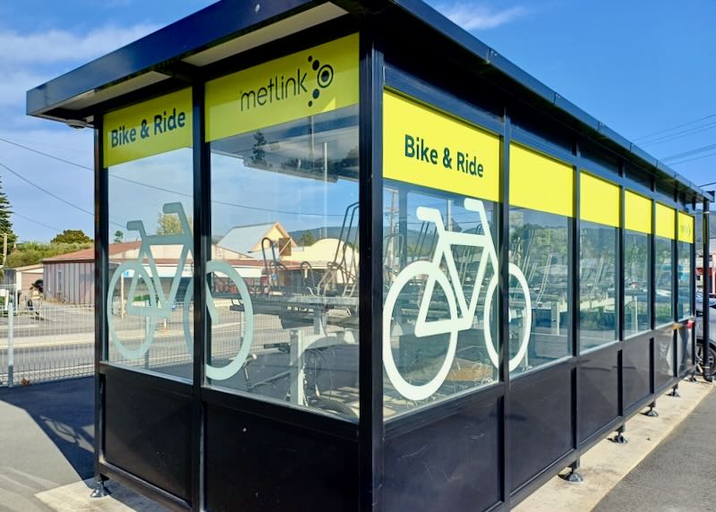 A glassed in shelter for bikes.