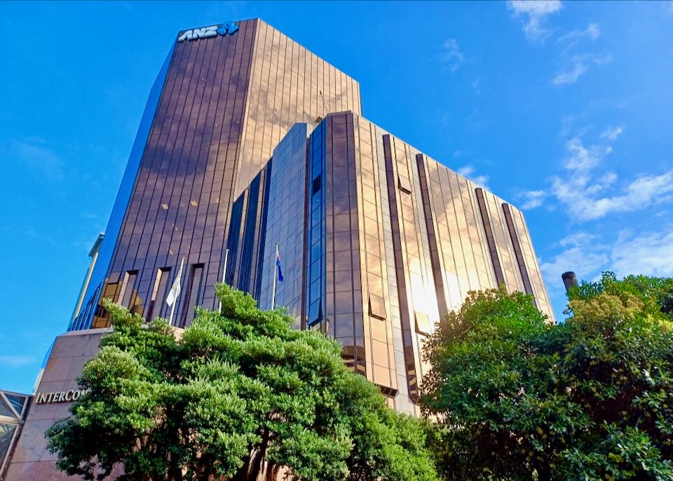 A large hotel with copper colored windows glows in the sun.