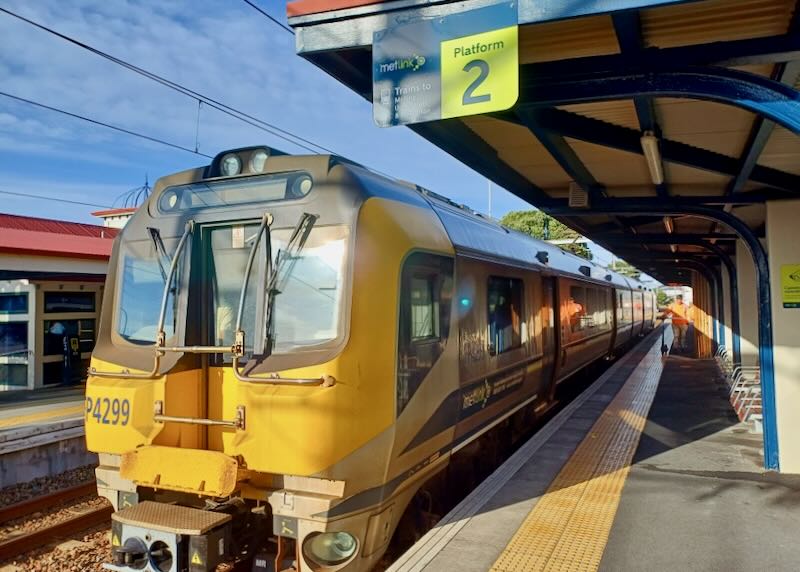 A large yellow and black train sits at a station.