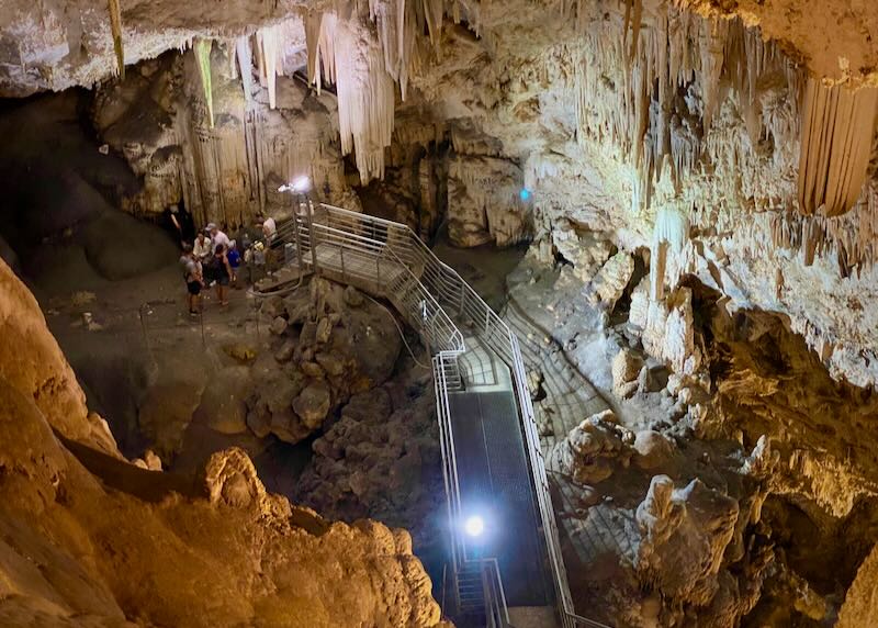 View from above of visitors in a deep cave.