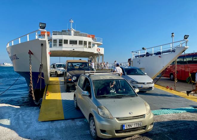 Cars departing a ferry boat at a pier on a Greek island.