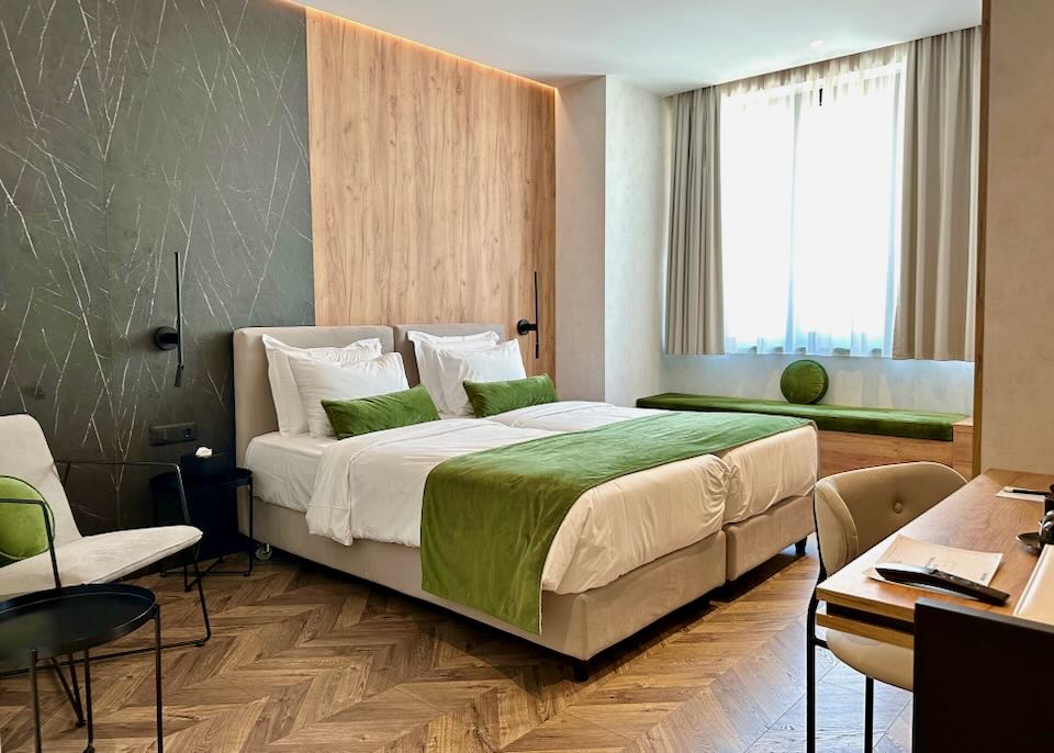 Hotel room with herringbone wood floors and tall windows