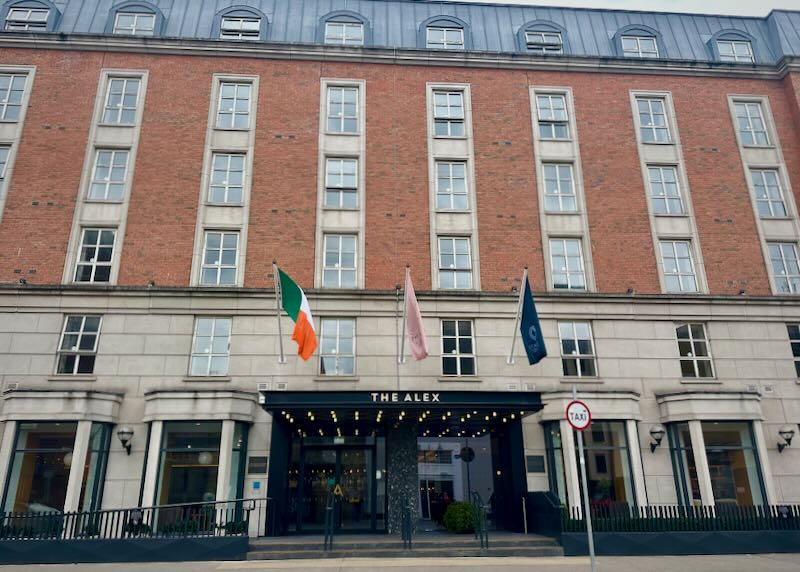 Red brick luxury hotel building with doorman. 