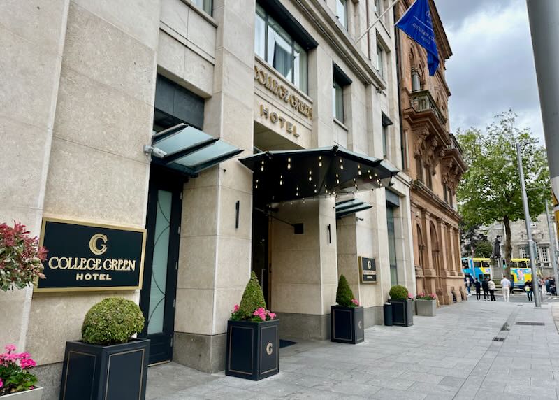 Side view of a covered hotel entrance, flanked by potted plants