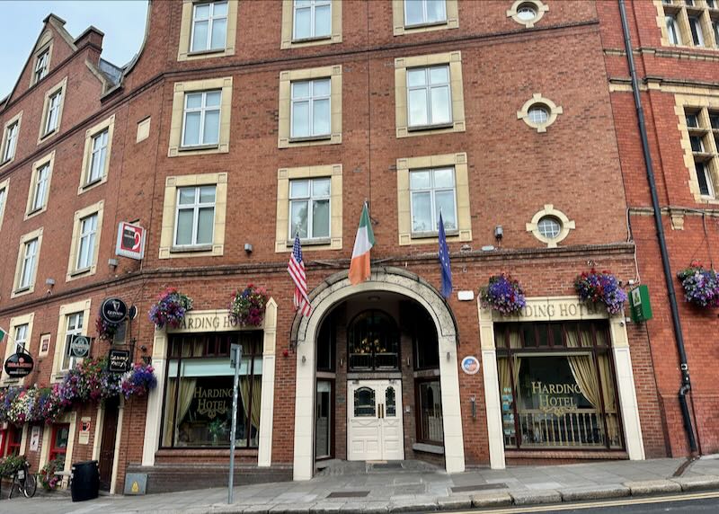 Entrance to a red brick hotel set on a hill.